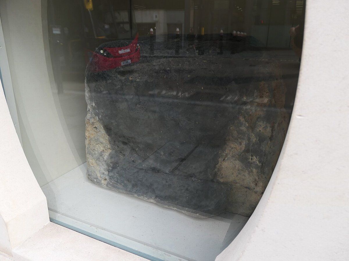 London Stone, a battered chunk of limestone set into a glass case on Cannon Street